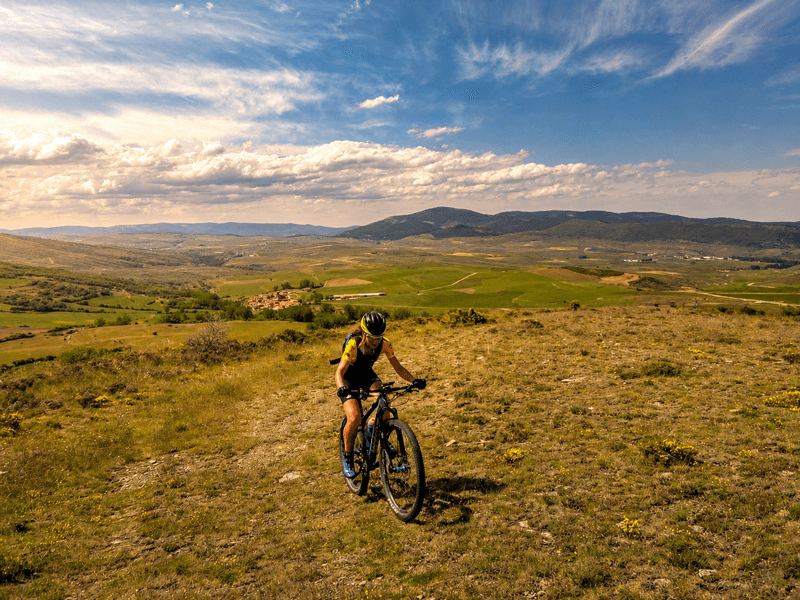 Maite subiendo en bici por un sendero de la sierra en la comarca de Tierras Altas
